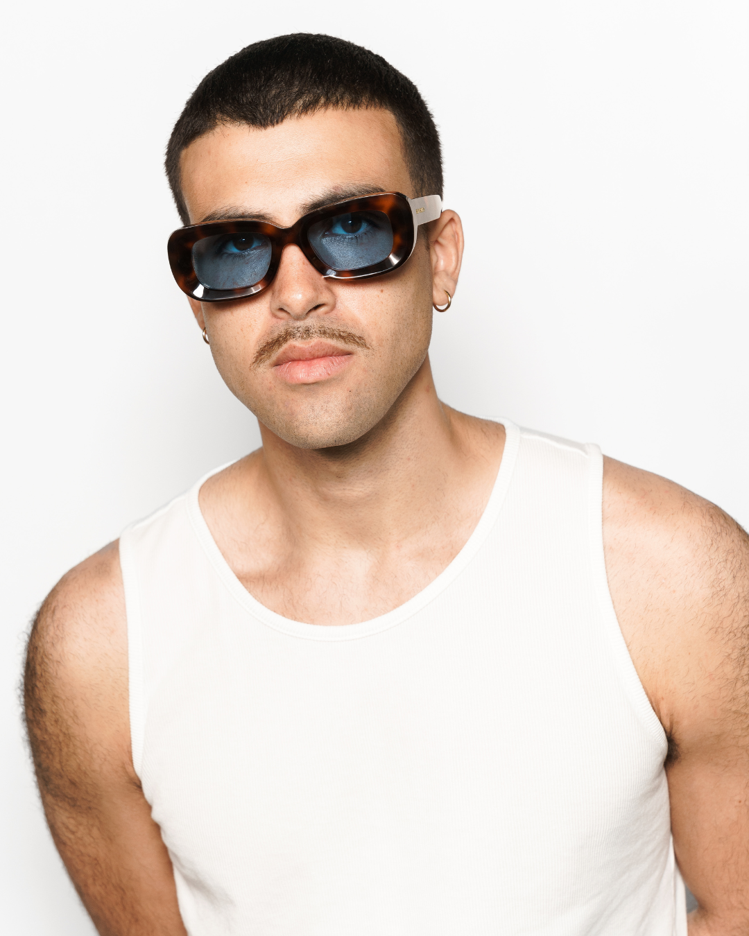 Model image of Rewrites tortoiseshell rectangular sunglasses: Handcrafted in Italy from 100% premium Mazzucchelli acetate, these tortoiseshell rectangular sunglasses feature a blue see-through TAC polarized lens for superior visual clarity and polarization. They include a scratch-resistant coating that blocks 100% harmful UV rays up to 400 nanometers. Highly impact-resistant and unisex, complete with our Rewrites logo in gold on the outside temples.